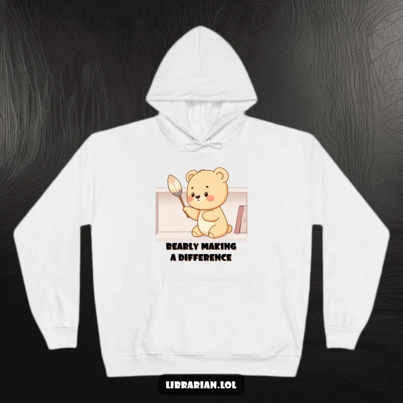 Funny bear cub hoodie, using a feather duster to clean a shelf, radiating warmth and humor. Ideal for cozy, amusing wear.