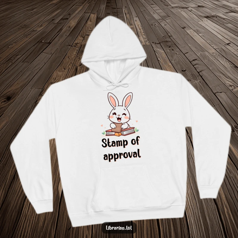 Cozy hoodie featuring a happy rabbit with a giant rubber stamp over books, symbolizing joyful productivity and comfort.