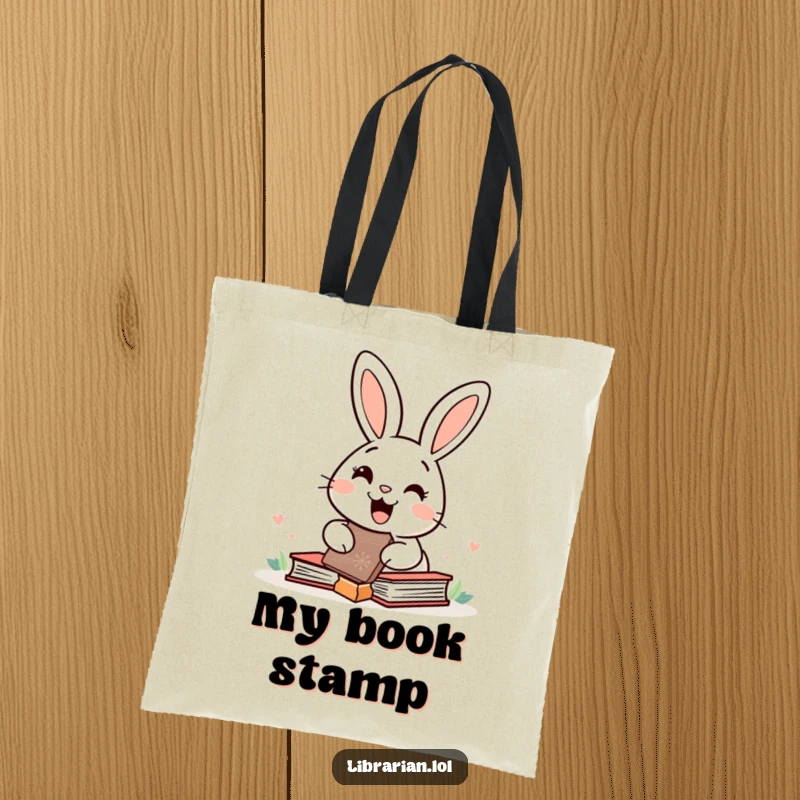Funny happy rabbit stamping books with a giant rubber stamp, depicted on a tote bag for stylish and joyful book transport.